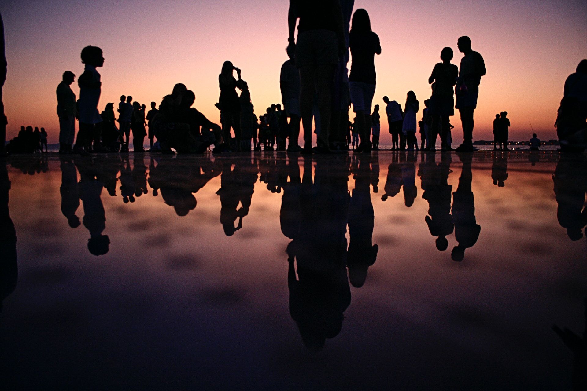 Eine Gruppe von Menschen steht am Strand und genießt die Gesundheitsbrise.